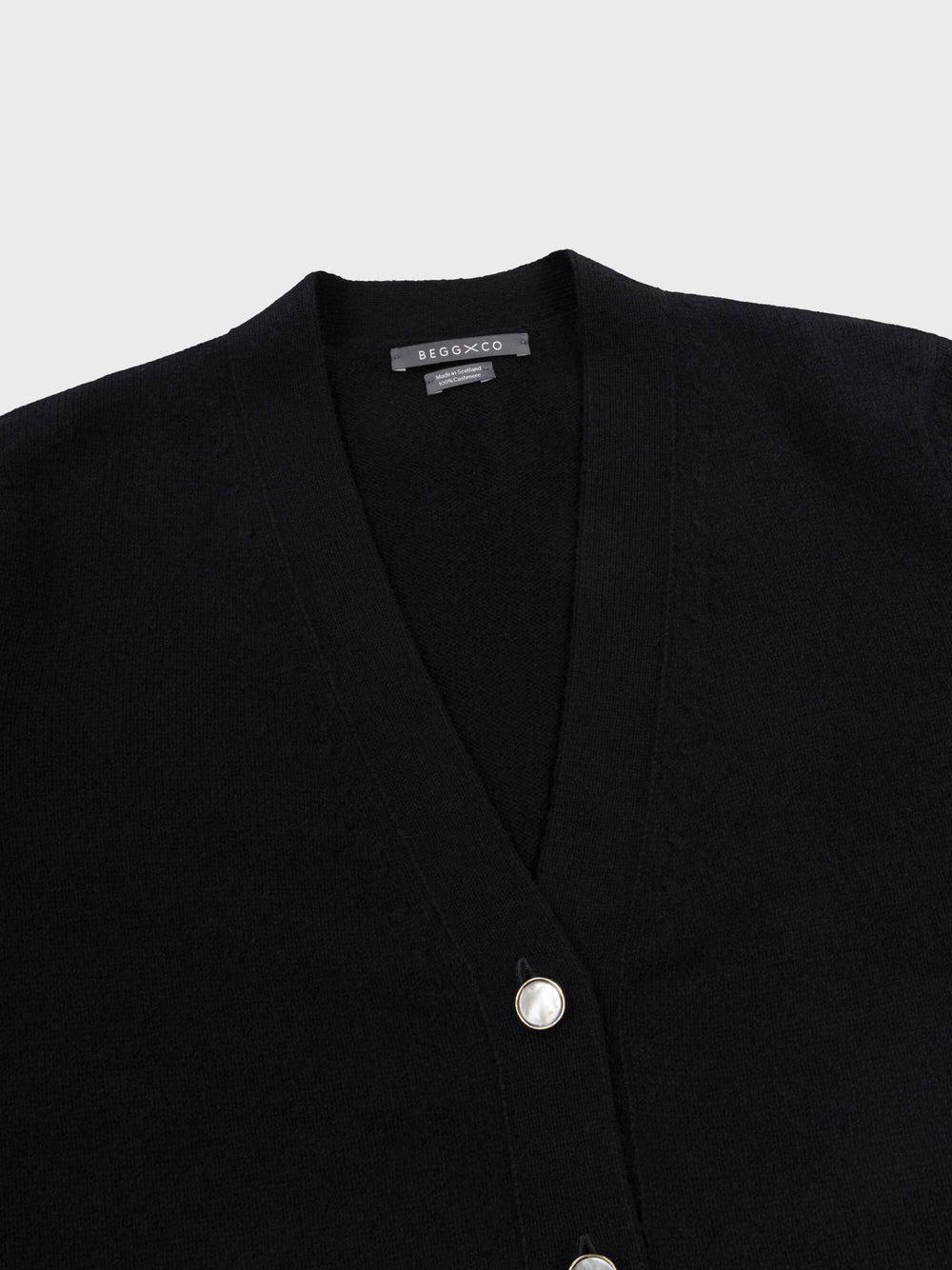 womens long black cashmere cardigan with pearl buttons neck detail on grey background