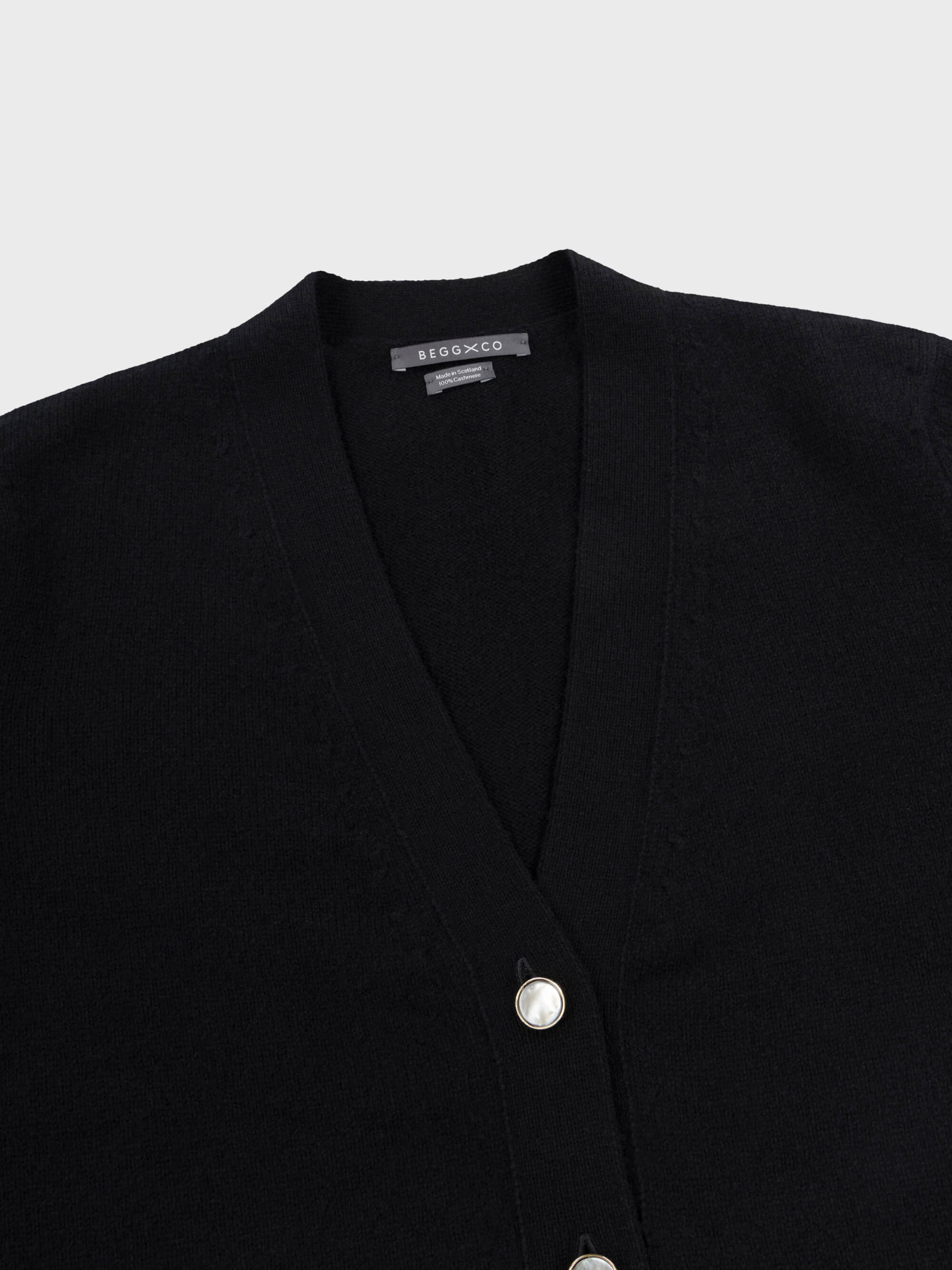 womens long black cashmere cardigan with pearl buttons neck detail on grey background