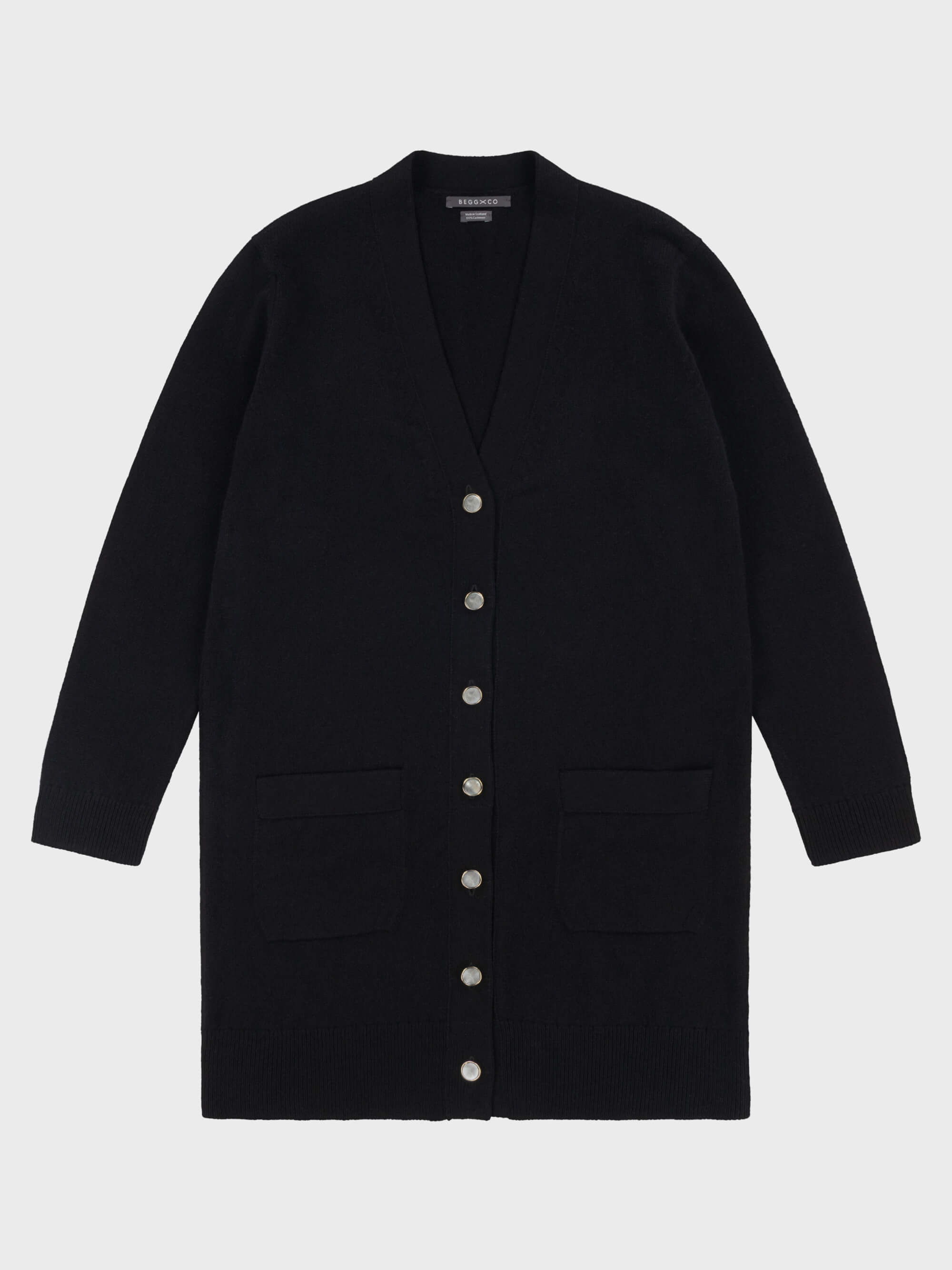 womens long black cashmere cardigan with pearl buttons and pockets on a grey background