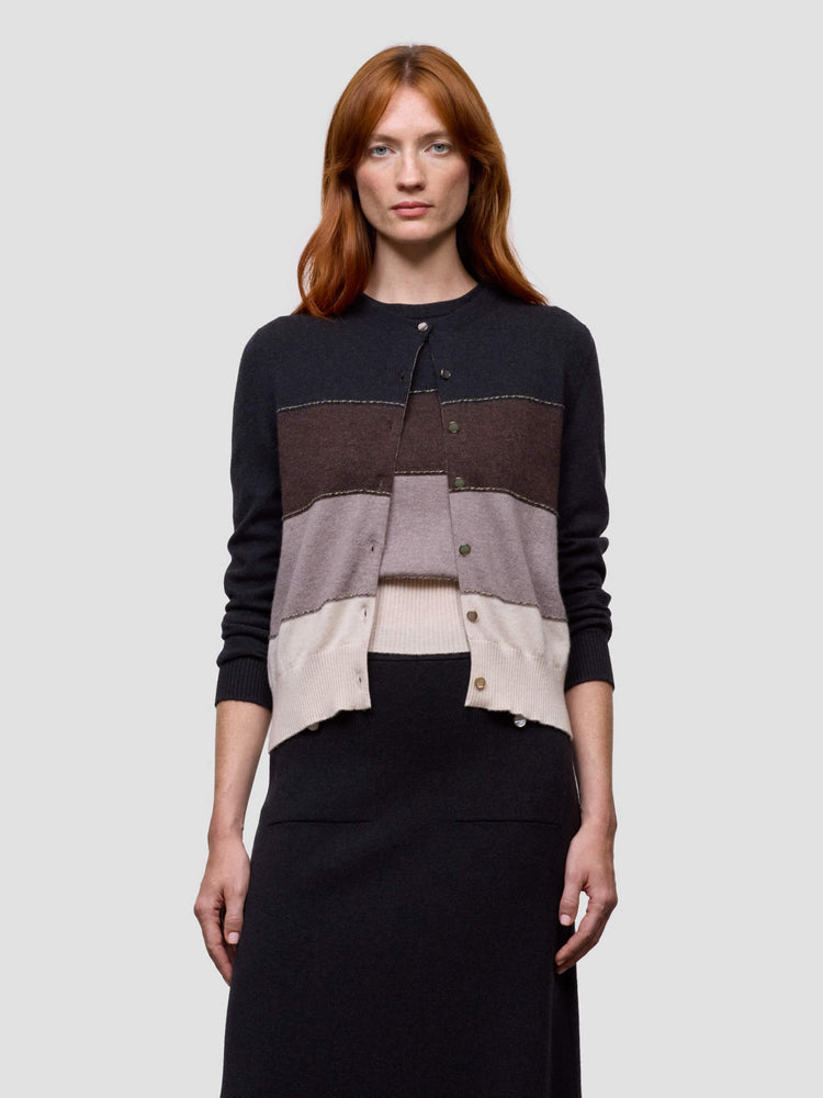 Woman wearing a color-blocked cashmere sweater with a plain background