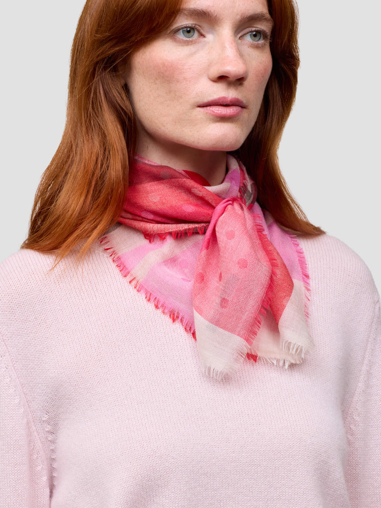 Woman wearing a pink cashmere scarf with a white background