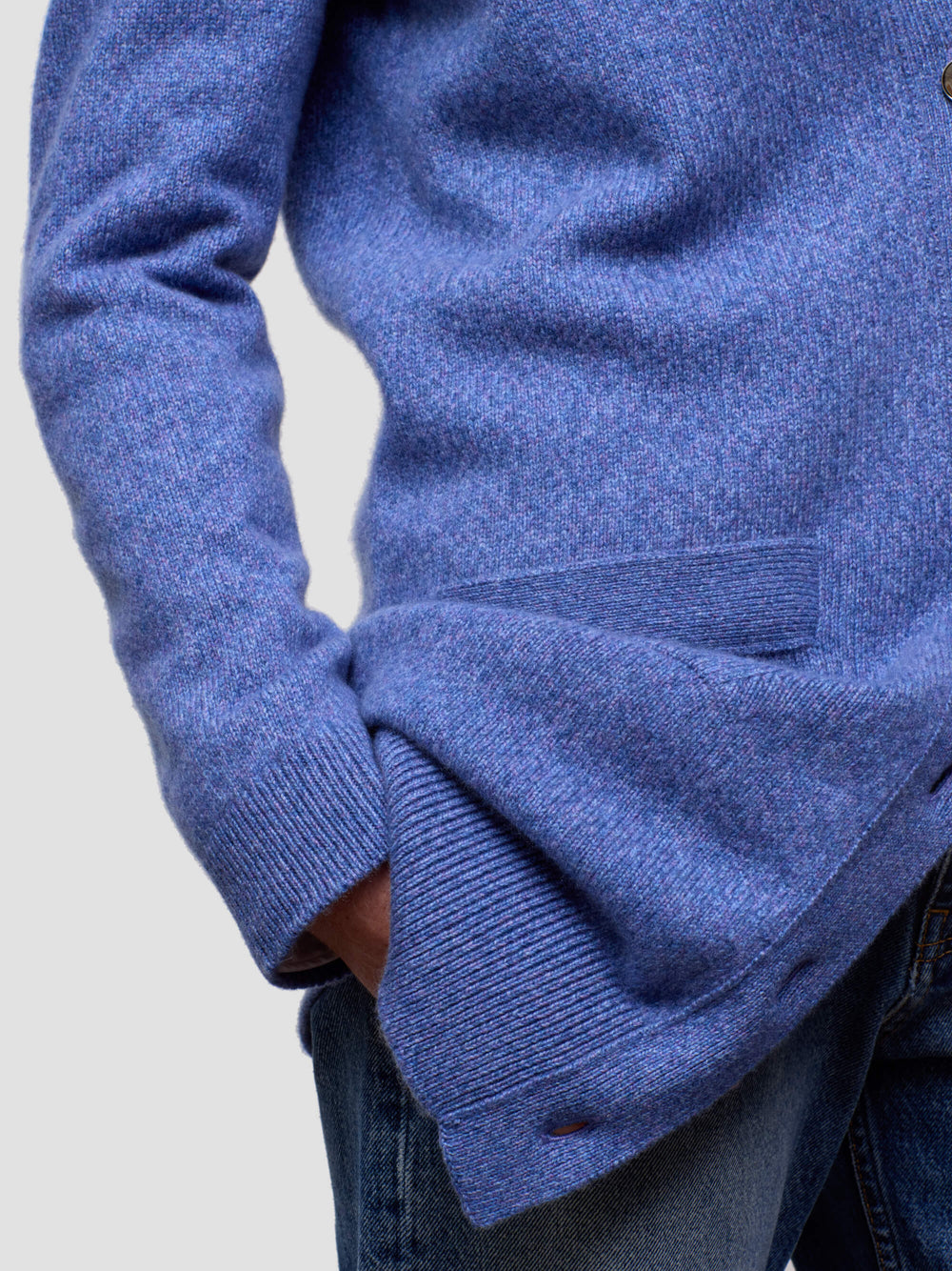 Close-up of a blue cashmere cardigan with a plain background