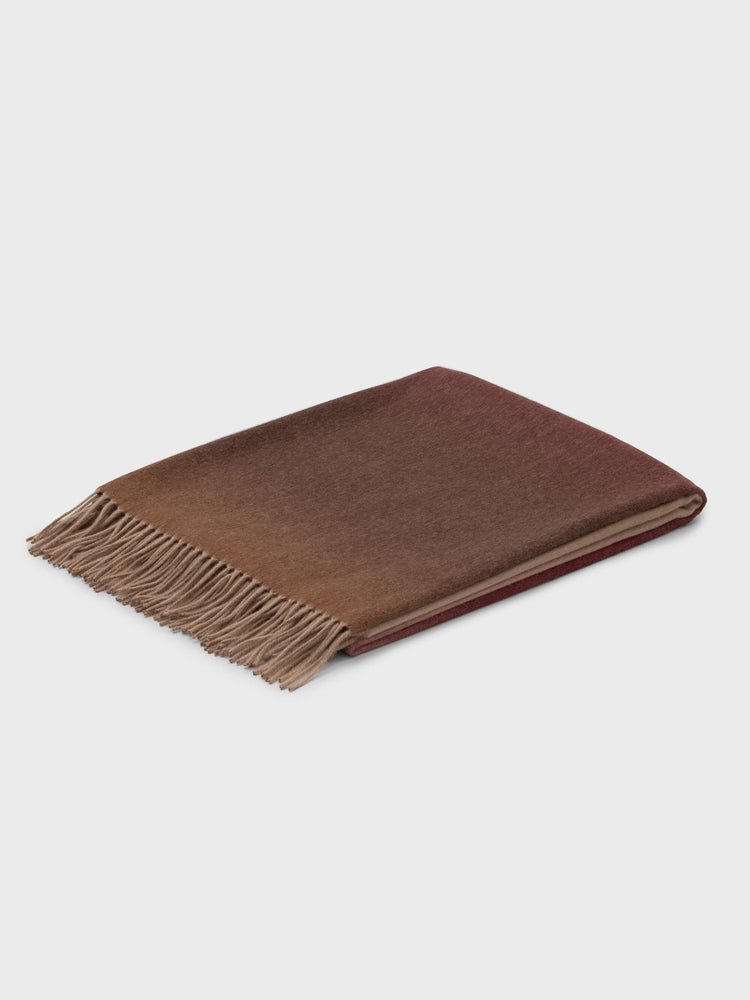 folded cashmere throw with red and brown gradient and fringe detail