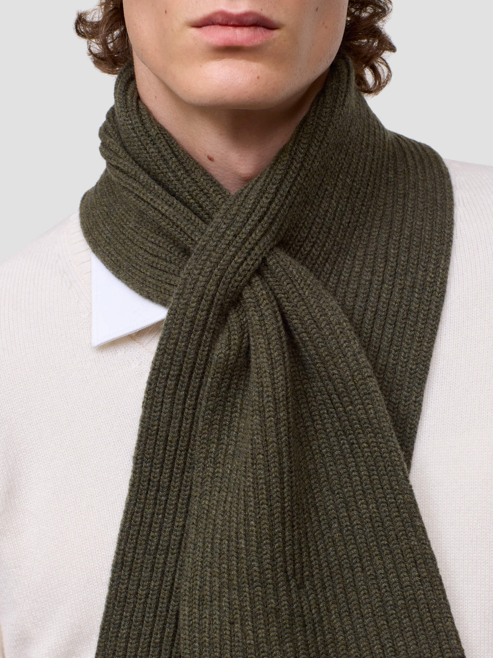 Person wearing a green scarf with a plain background