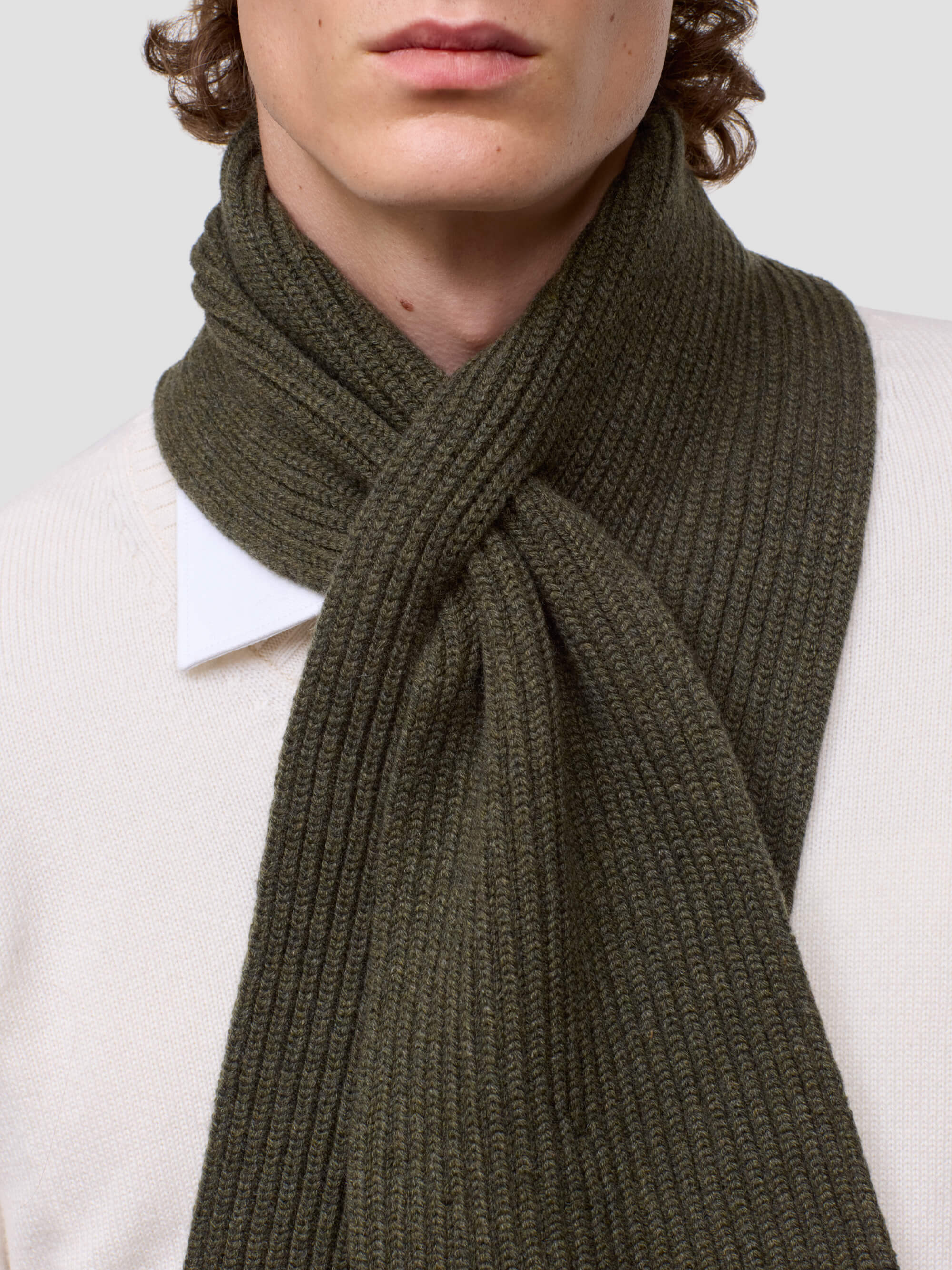 Person wearing a green scarf with a plain background