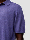 sleeve detail of a man wearing a short sleeve cashmere polo on a grey background