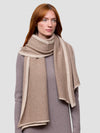 woman wearing a brown cashmere wrap and grey cashmere dress on a grey background