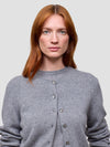 Woman wearing a gray cashmere cardigan on a light gray background