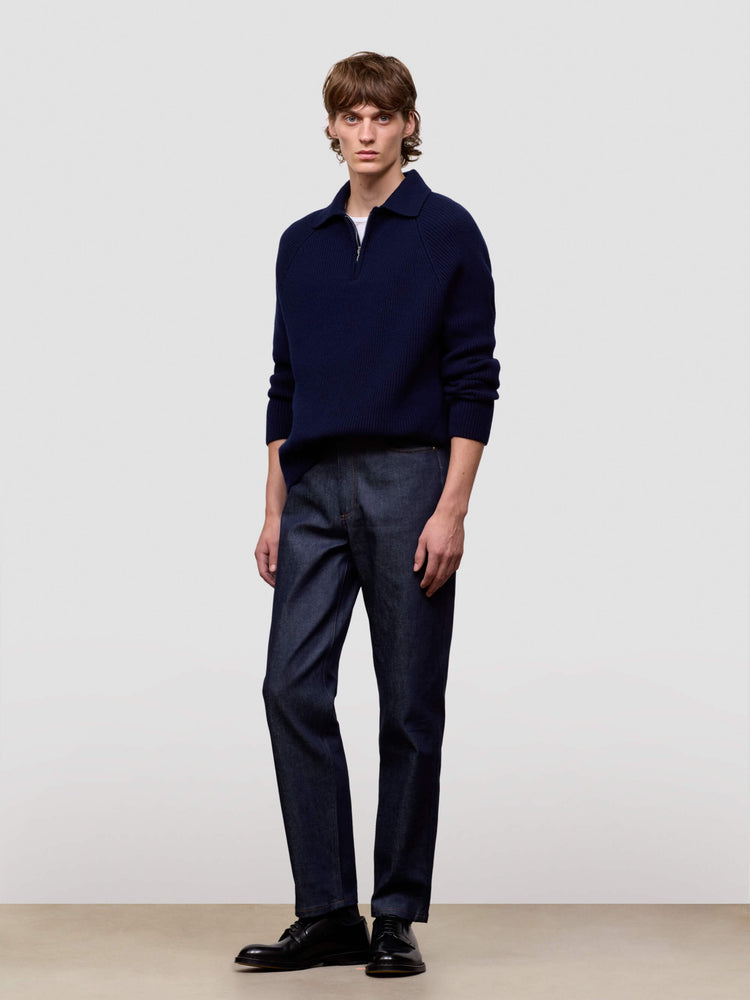 man wearing a navy blue cashmere zip sweater on a light gray background