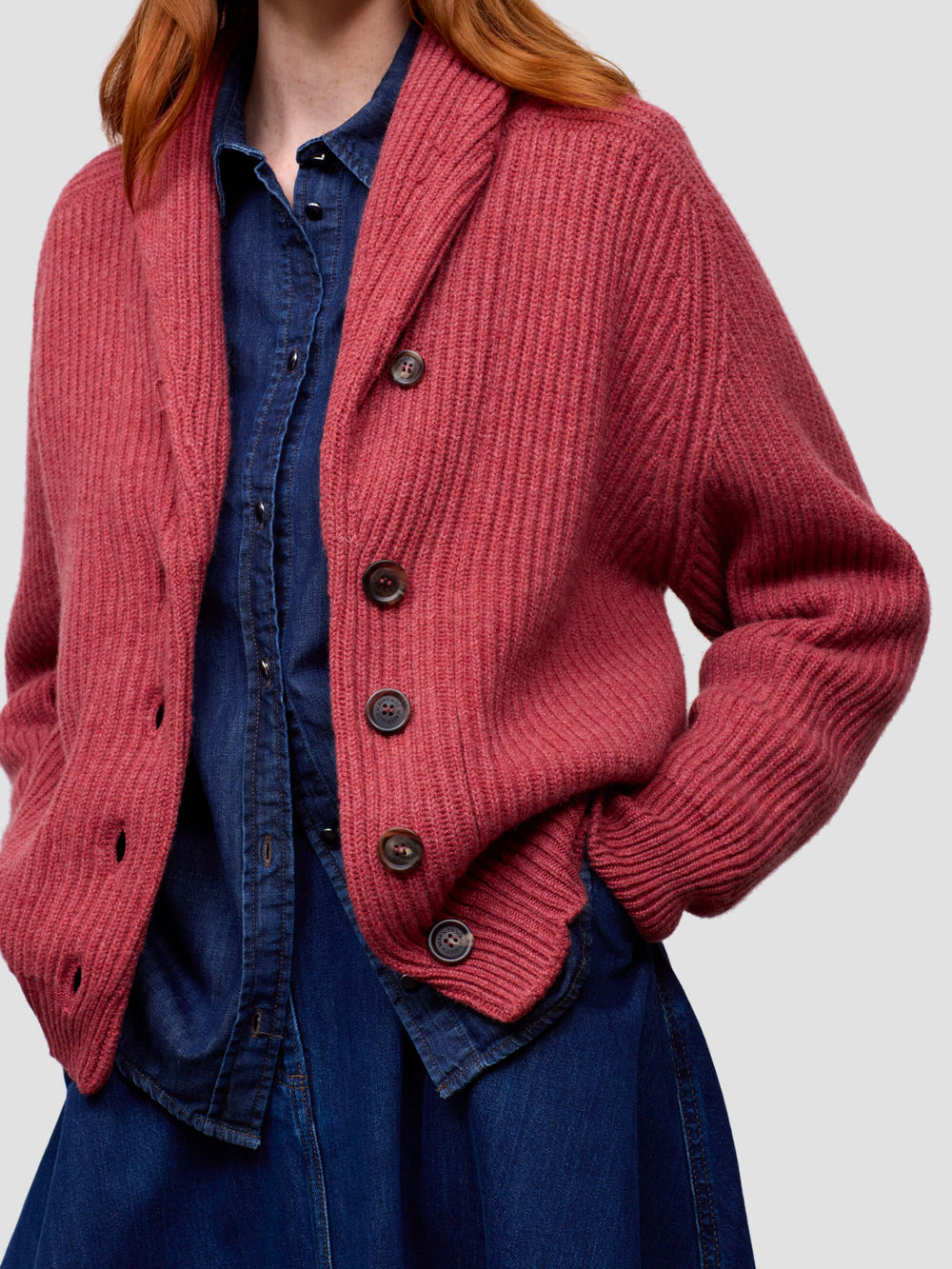 Woman wearing a red cashmere cardigan, blue dress on a white background