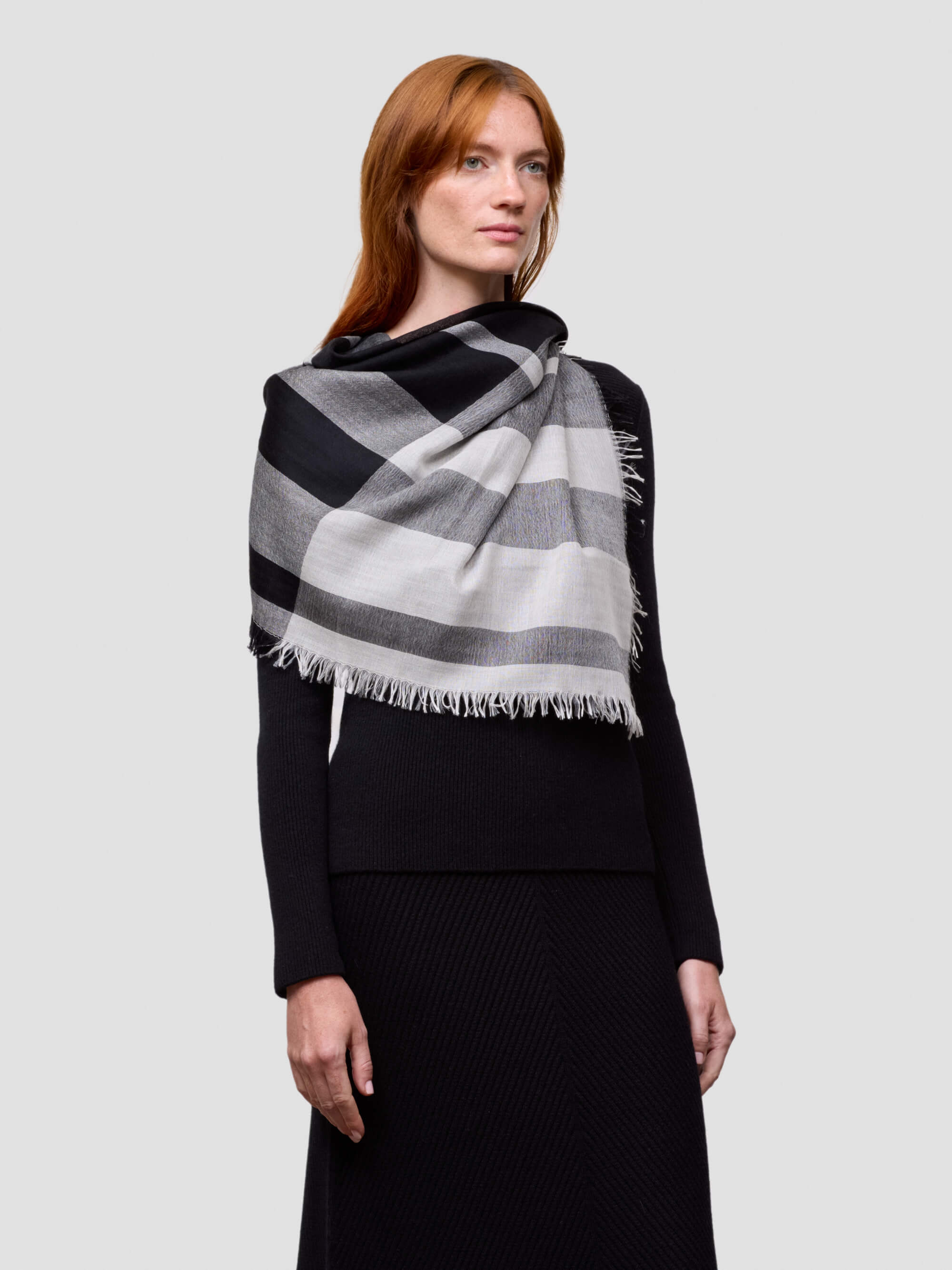 Woman wearing a black and white checkered scarf on a light gray background