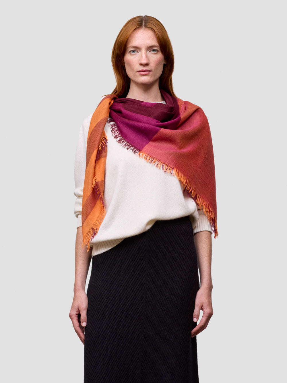 Woman wearing a multicolored scarf on a plain background