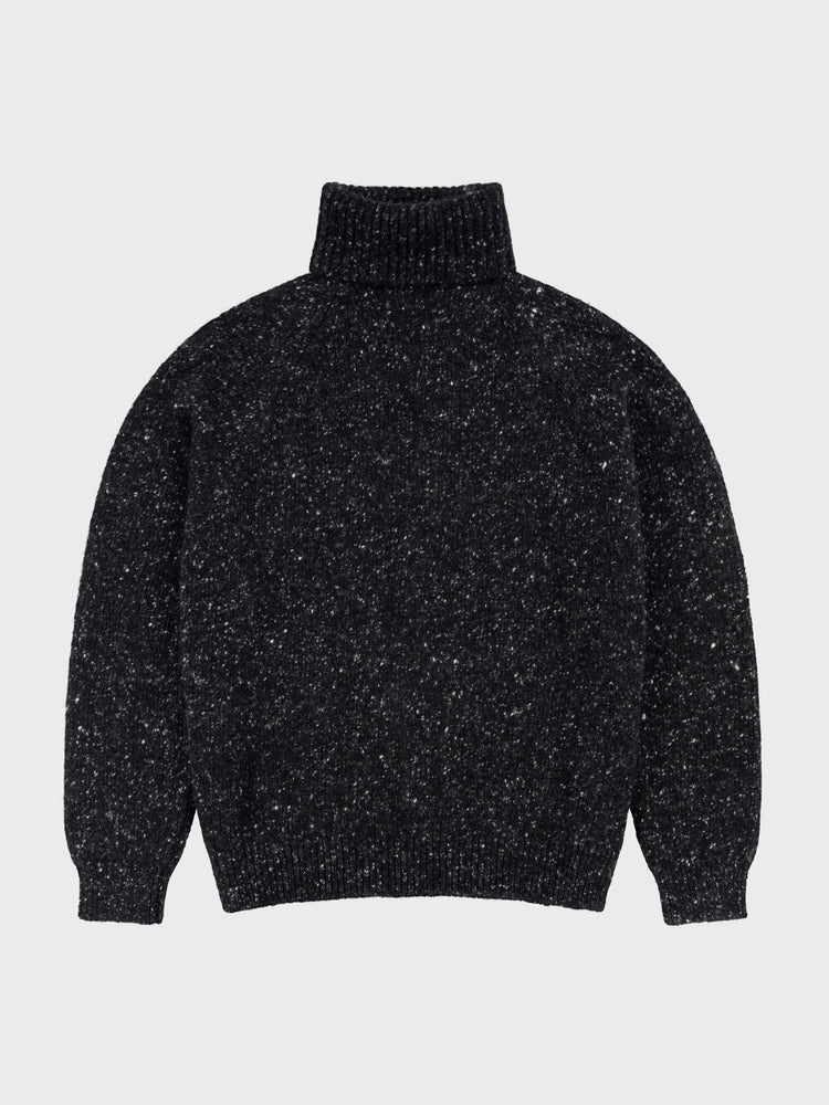 black chunky cashmere roll collar sweater with white speckles on a grey background