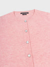 close up of a pink cashmere cardigan with pearl buttons on a grey background
