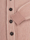 cuff and button close up on a pink ribbed shawl collar cardigan on a grey background