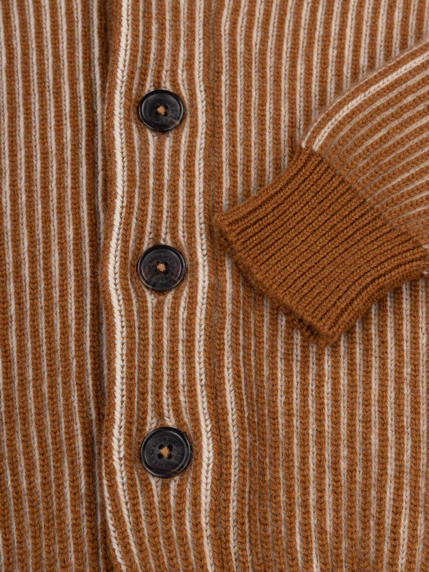 button and cuff detail of a brown and beige ribbed shawl collar cardigan