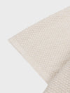 beige cashmere poncho short sleeve detail on a grey background