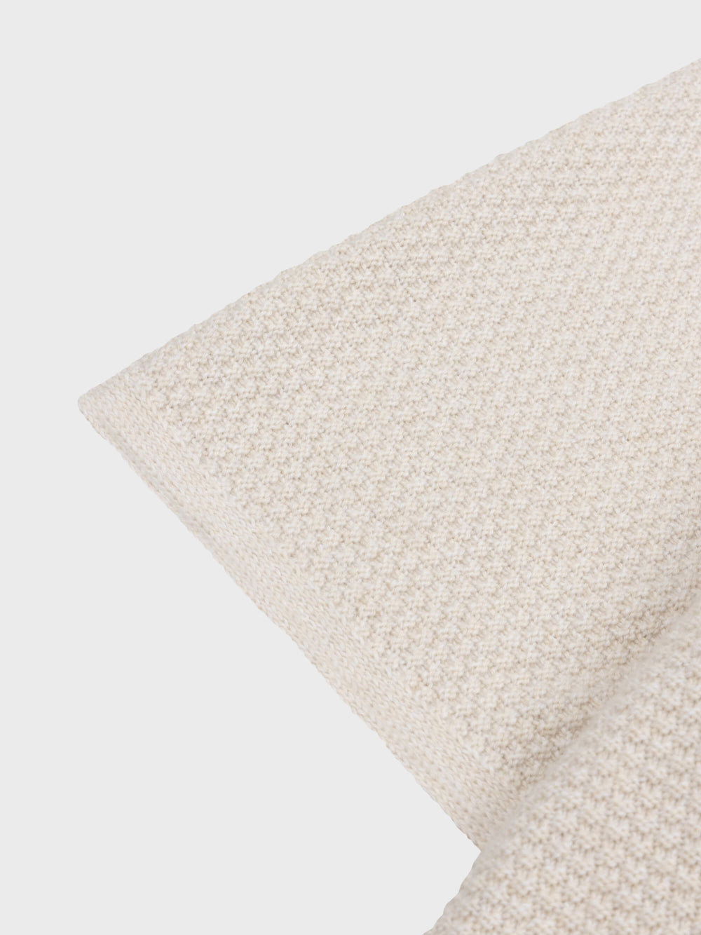 beige cashmere poncho short sleeve detail on a grey background