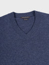 close up of a navy v-neck cashmere sweater on a grey background