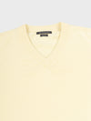 close up of a light yellow v-neck sweater on a grey background