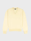 light yellow v-neck sweater on a grey background