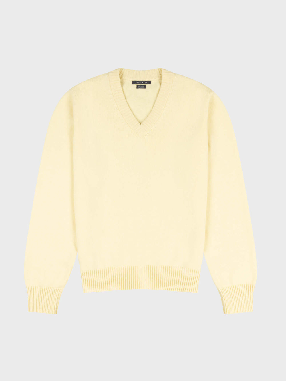 light yellow v-neck sweater on a grey background
