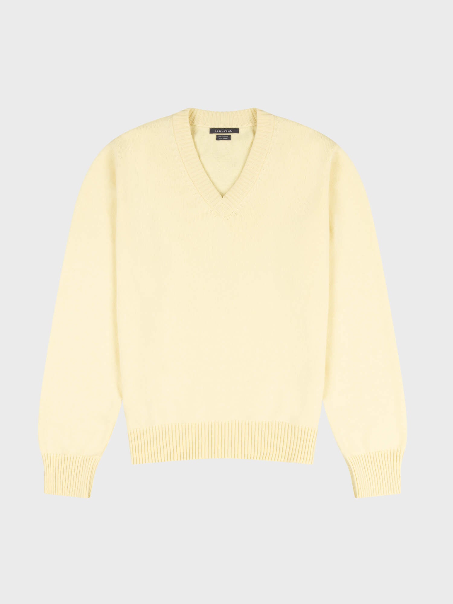 light yellow v-neck sweater on a grey background