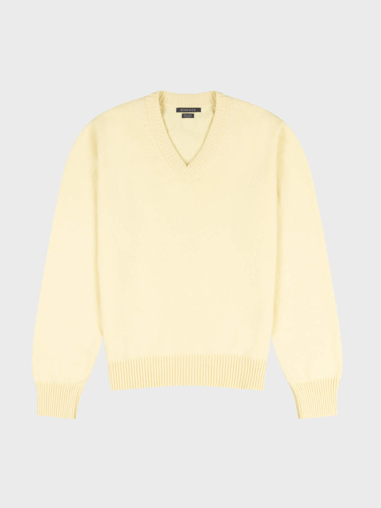 light yellow v-neck sweater on a grey background