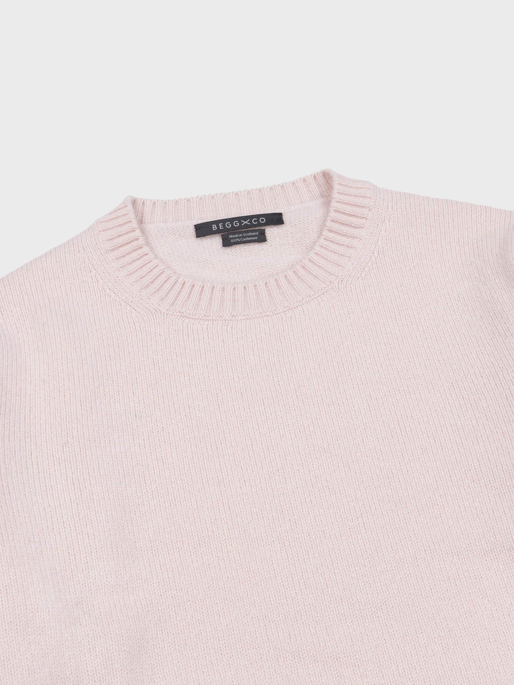 pale pink cashmere crewneck sweater ribbed collar detail on a grey background