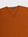 neck detail of a brown cashmere v-neck sweater on a grey background