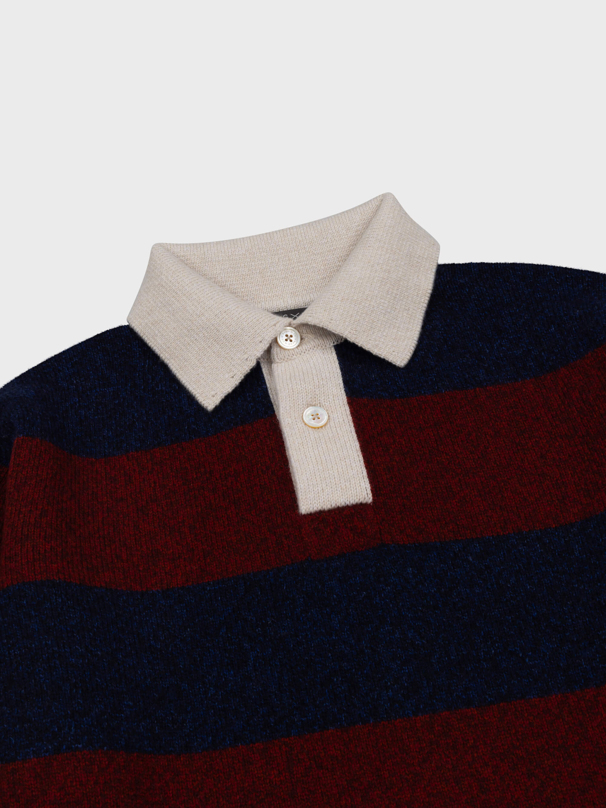 red and navy striped cashmere rugby shirt with contrasting white buttoned collar on a grey background