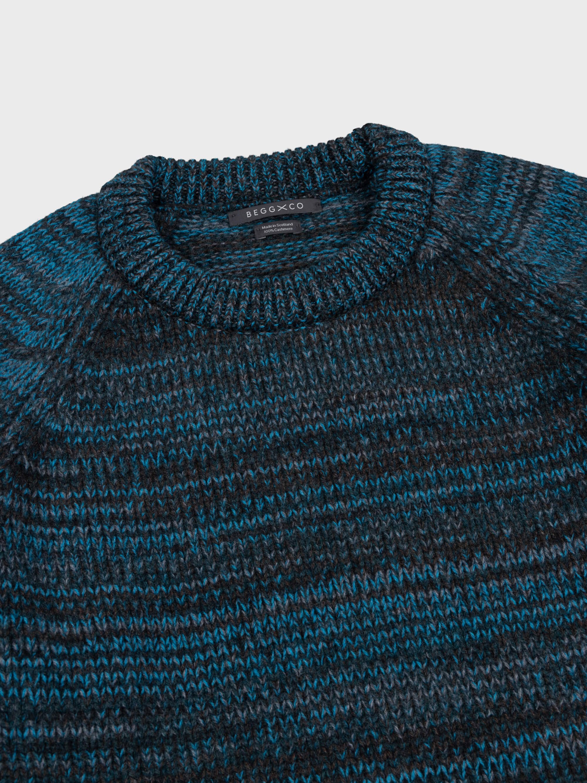 blue and dark green striped cashmere crewneck sweater ribbed collar on a grey background