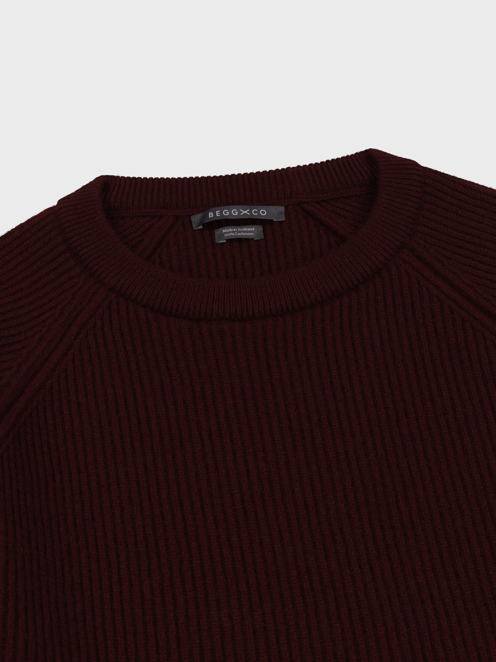 mens wine red cashmere crew neck ribbed sweater collar detail on a grey background