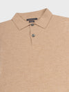 collar detail of a beige cashmere short sleeve polo on a grey background
