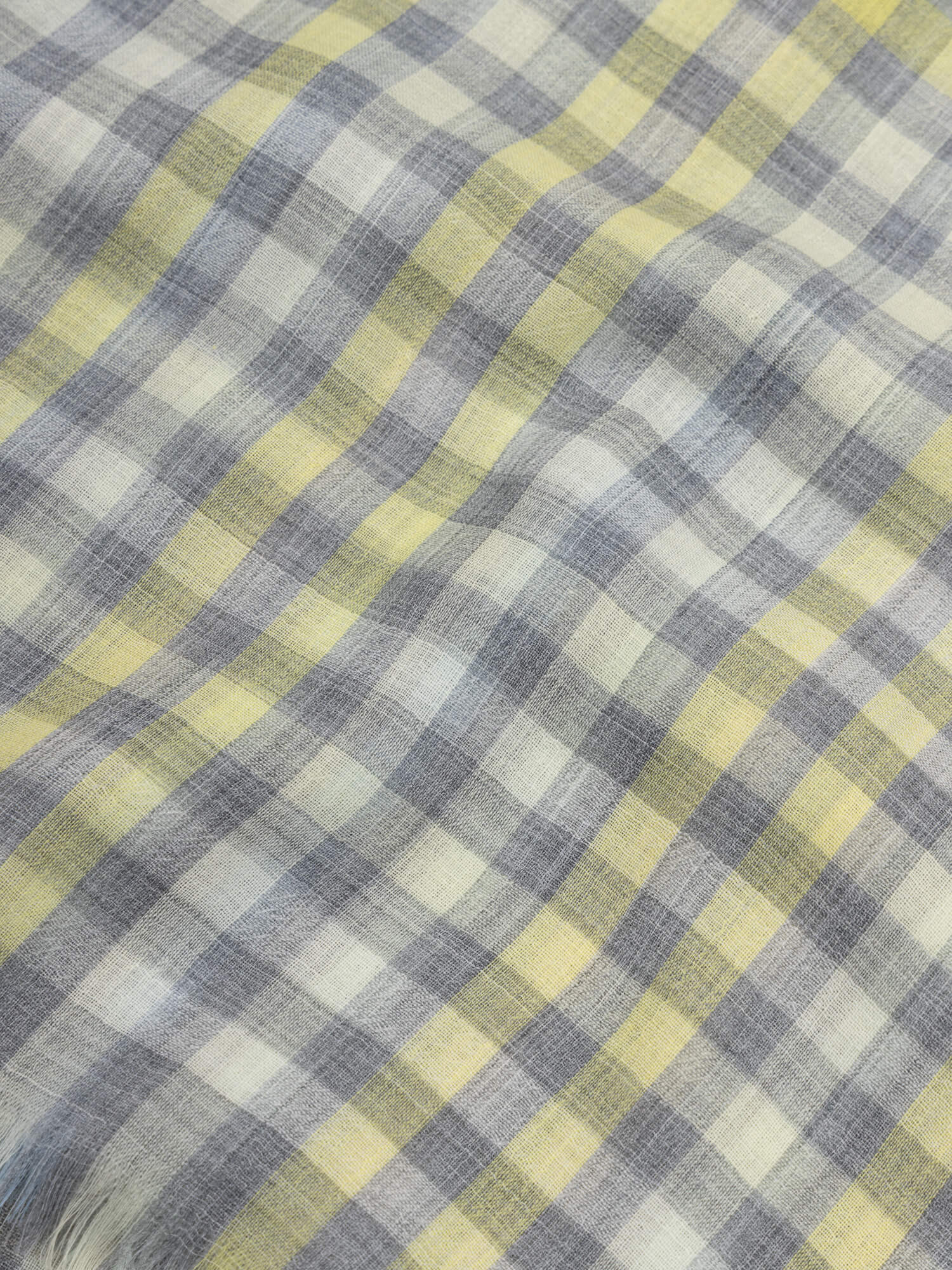 close up of a cashmere scarf with grey and yellow checks