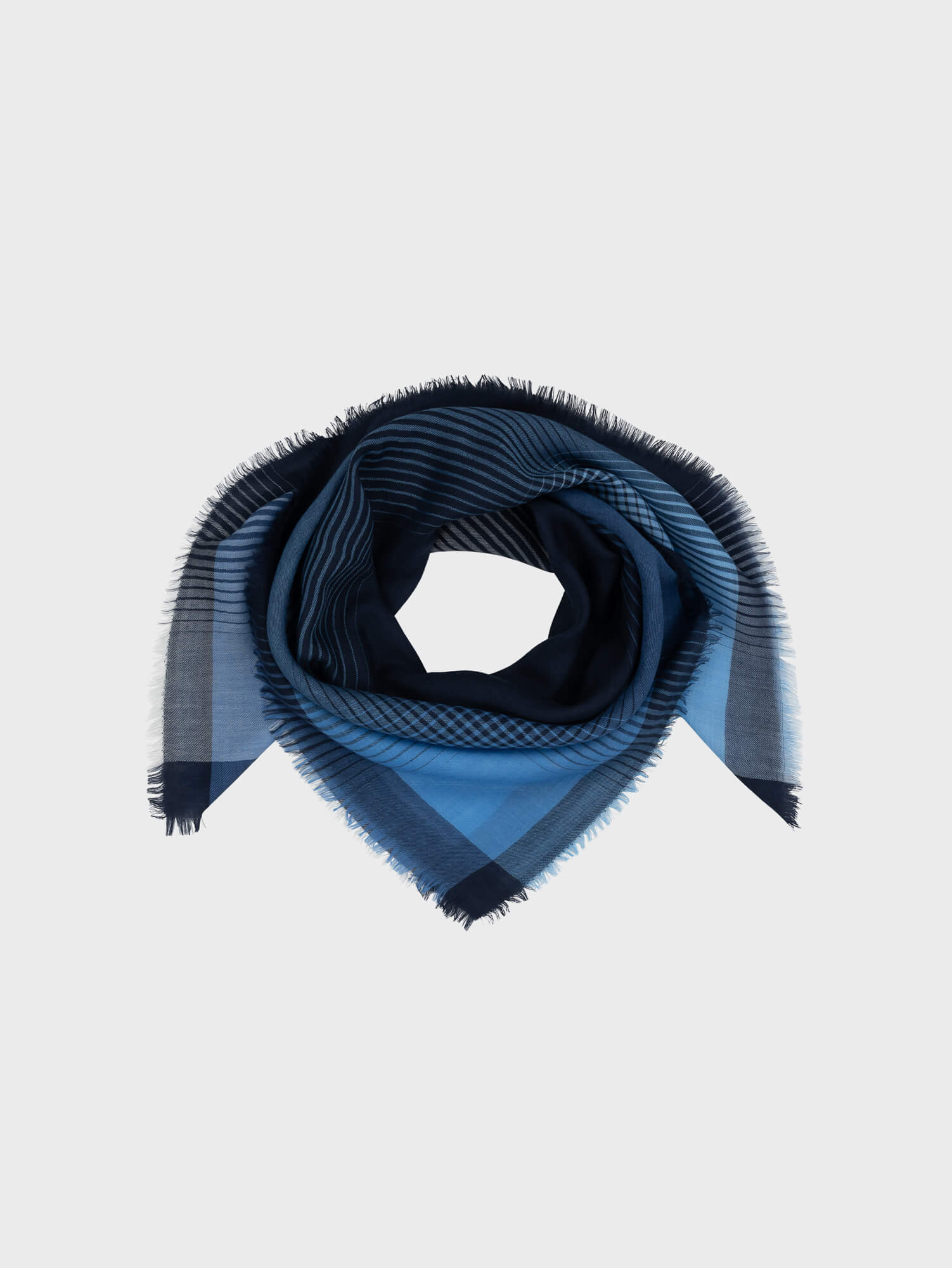 blue and navy square cashmere scarf with gradient check design on a grey background