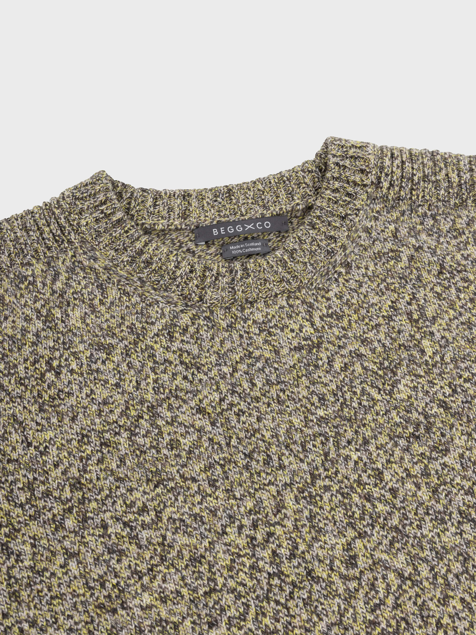 marl green and yellow cashmere crewneck sweater collar detail on a grey background