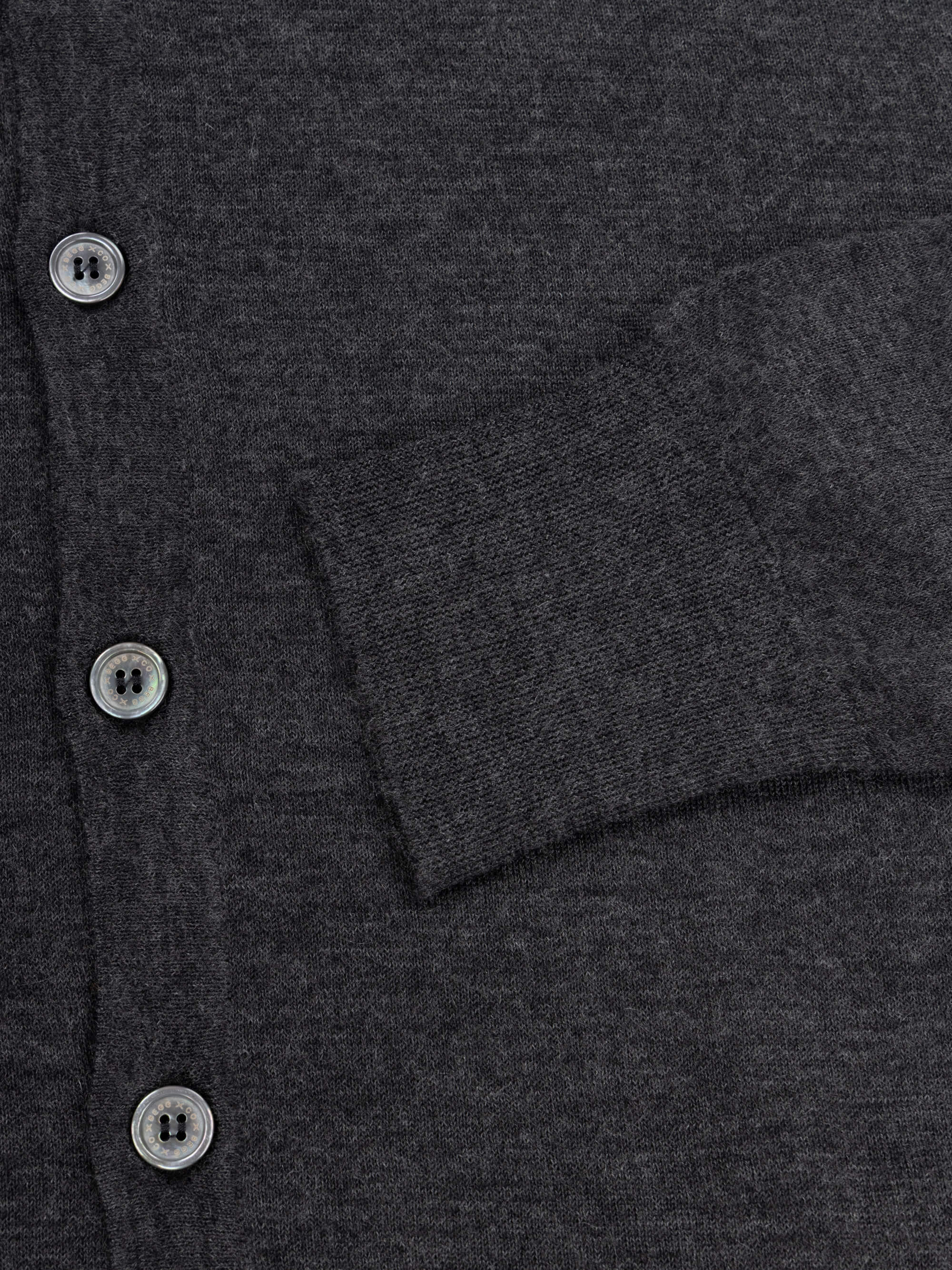 lightweight mens dark grey cashmere cardigan with collar and mother of pearl buttons and ribbed cuff detail on a grey background