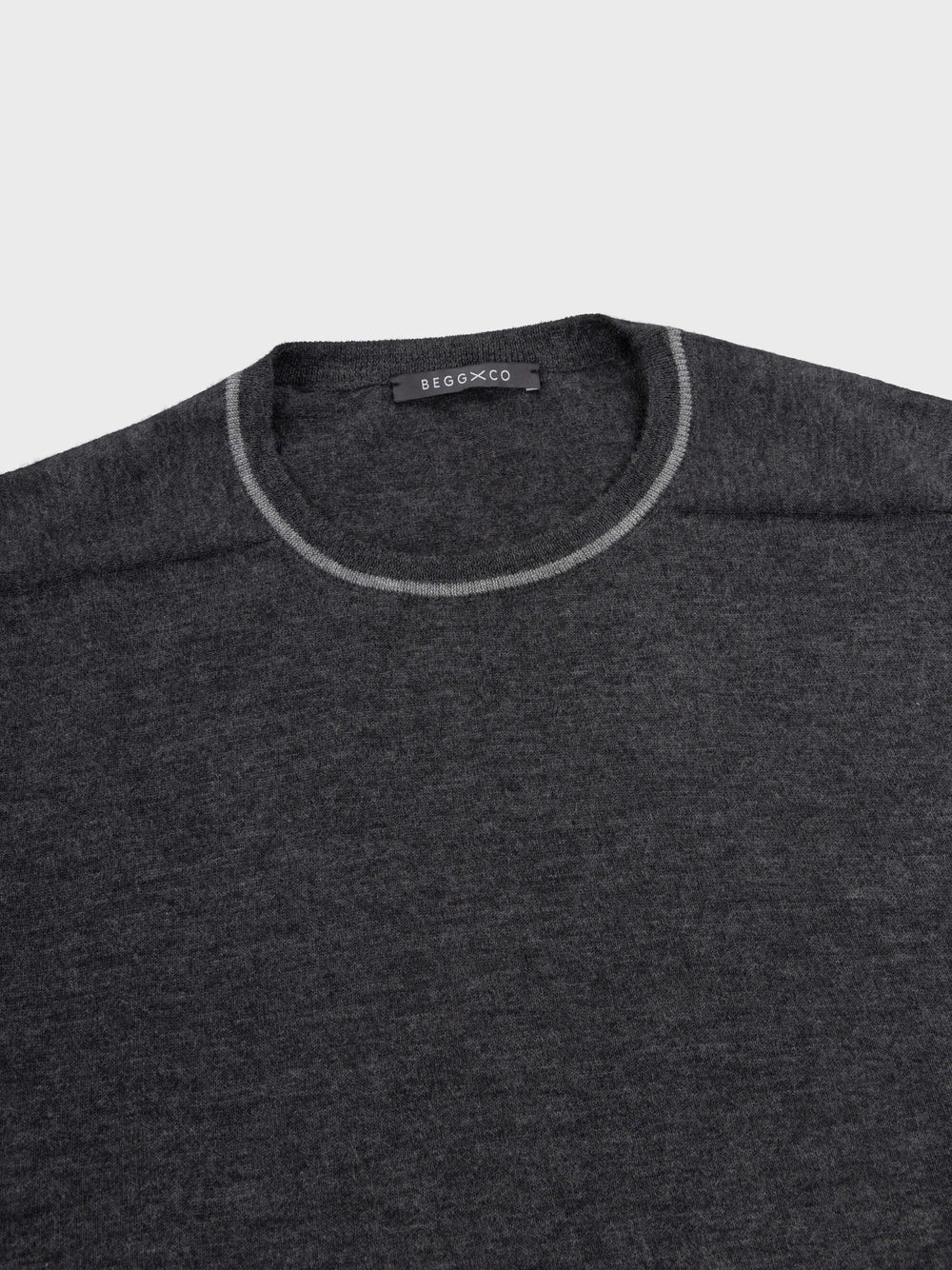 mens dark grey cashmere crewneck sweater detail with light grey piping details on a grey background