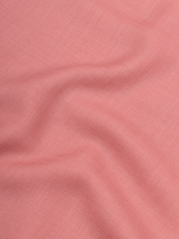 close up of a pink square cashmere scarf on a grey background