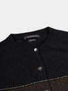 Close-up of a black and brown cardigan with 'Begg x Co' branding on a light gray background.