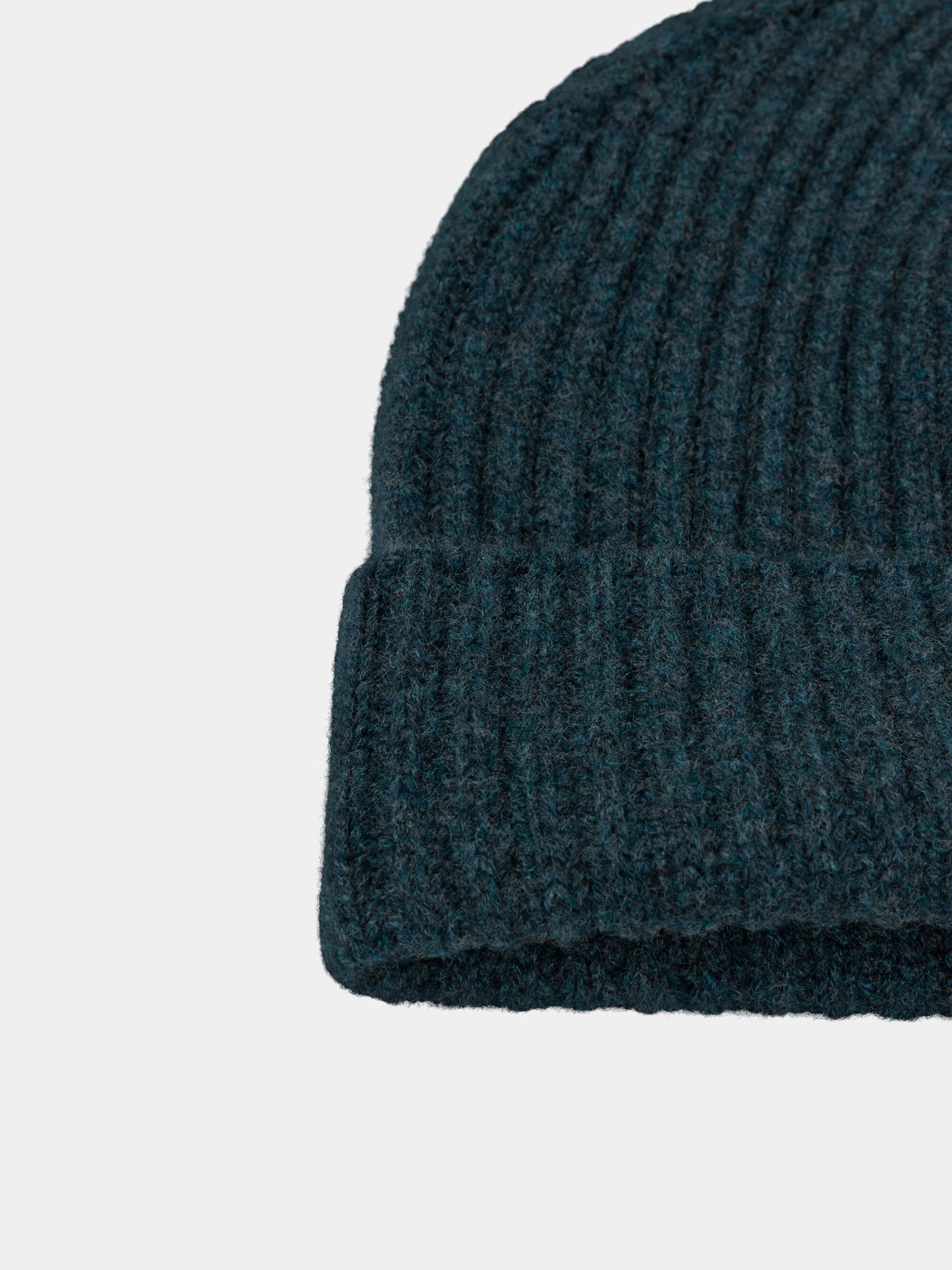Dark green cashmere knit beanie on a light gray background