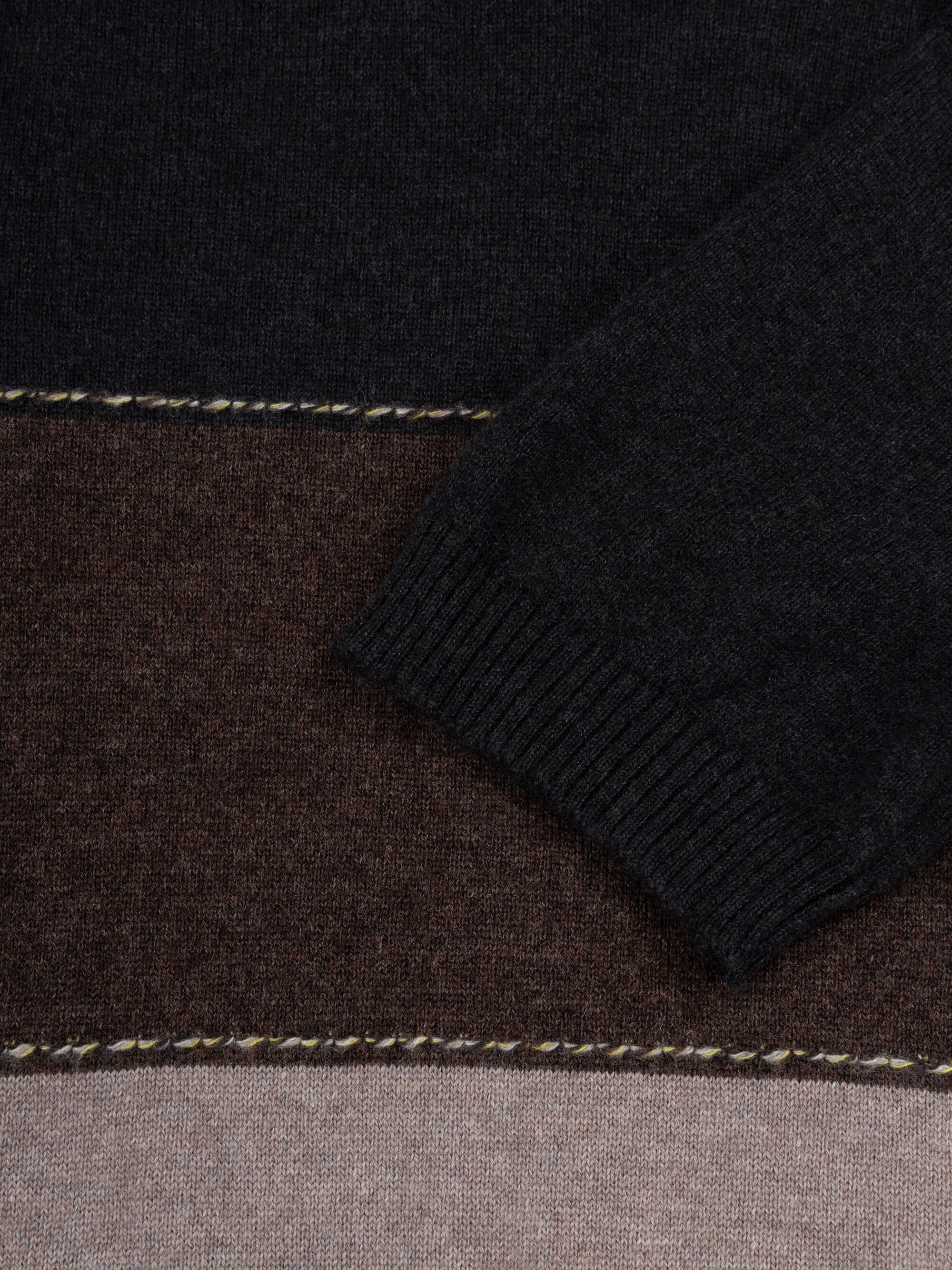 Color-blocked cashmere t-shirt with black, brown, and beige sections on a light gray background