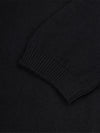 Close-up of a black cashmere t-shirt sleeve with ribbed texture.