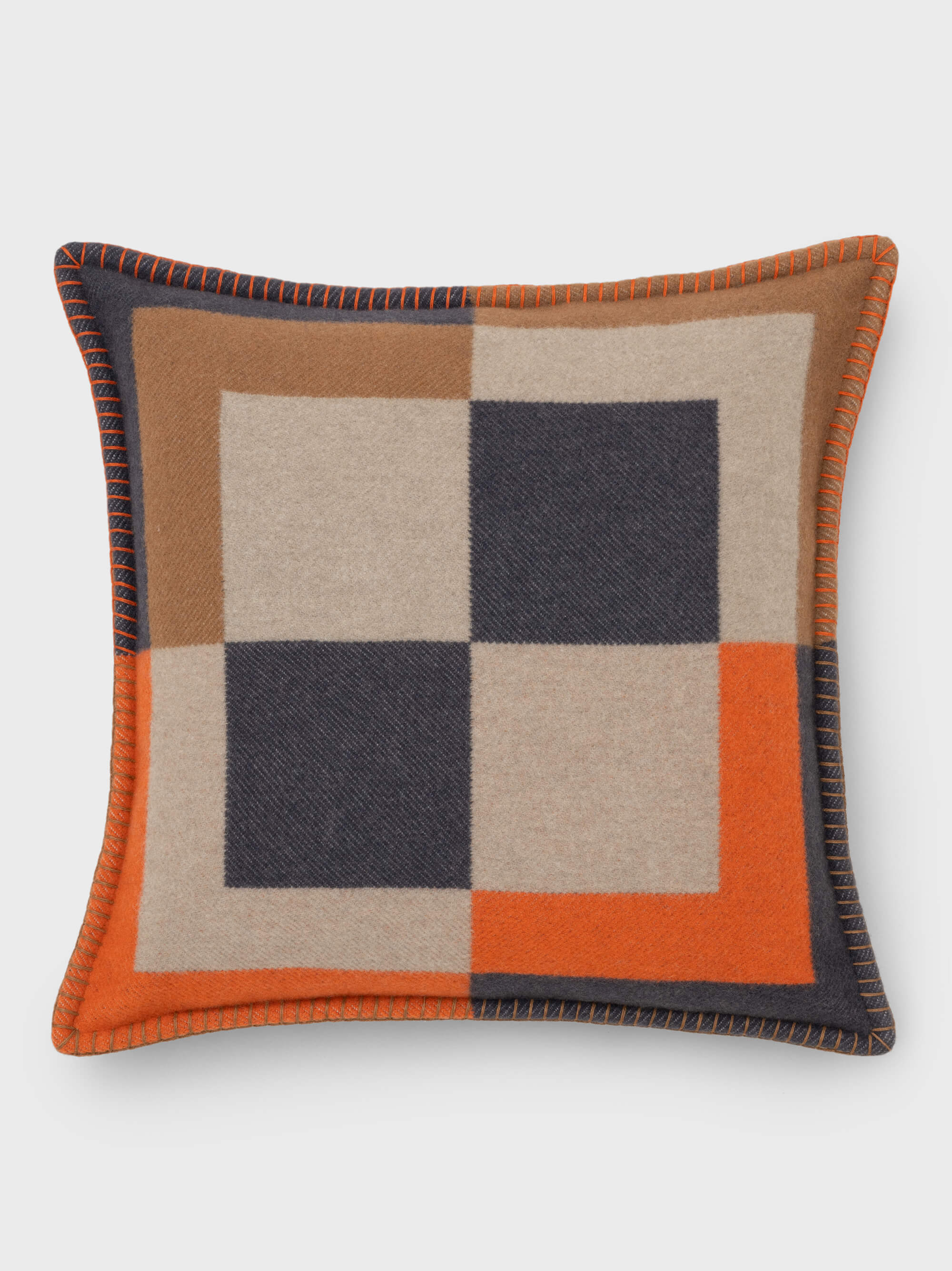 A checkered cushion with a contemporary design, featuring a blend of colors including beige, black, orange, and gray, with visible contrast stitching.