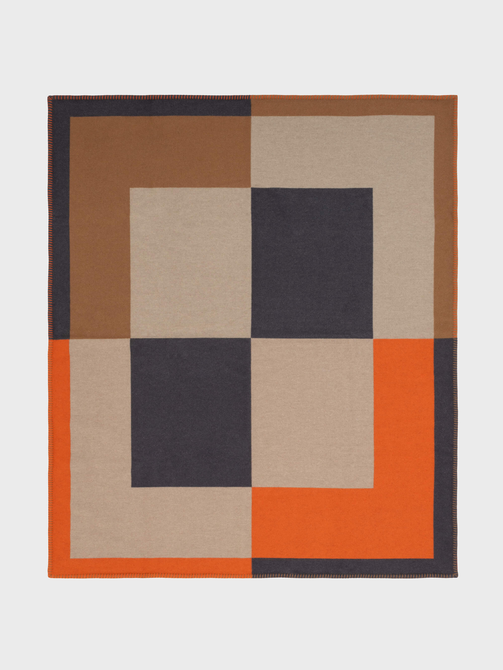 A checkered blanket with a modern design, featuring blocks of colors such as orange, beige, and brown, with contrasting stitching.