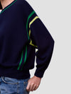 Navy sweater with green and yellow stripes on a plain background
