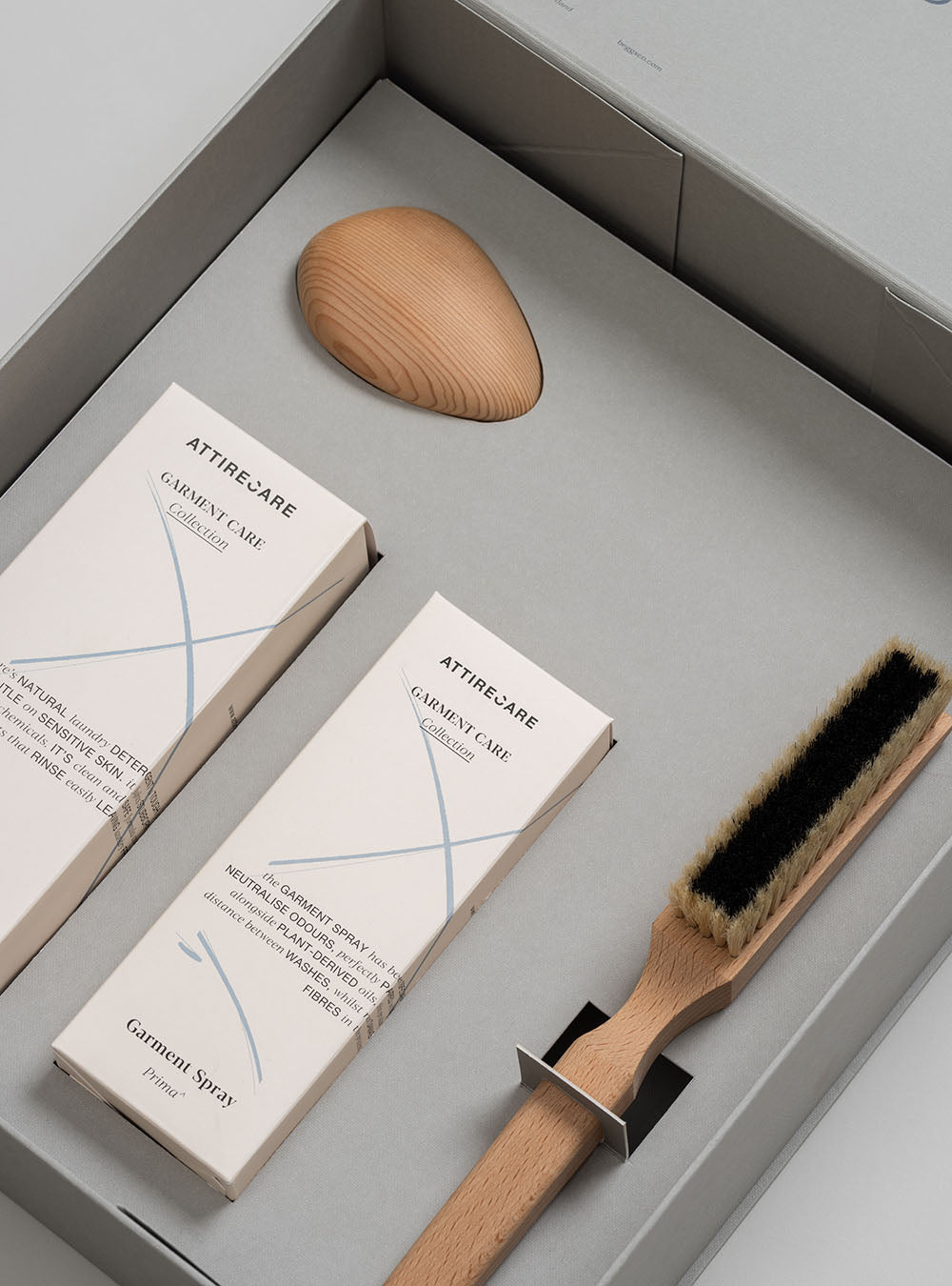 Image of the Begg x Co cashmere Care Kit, featuring boxes of natural laundry determgent and garment spray, a wooden cashmere brush and a cedar pebble. - Begg x Co
