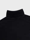 Close-up of a black turtleneck sweater on a light gray background