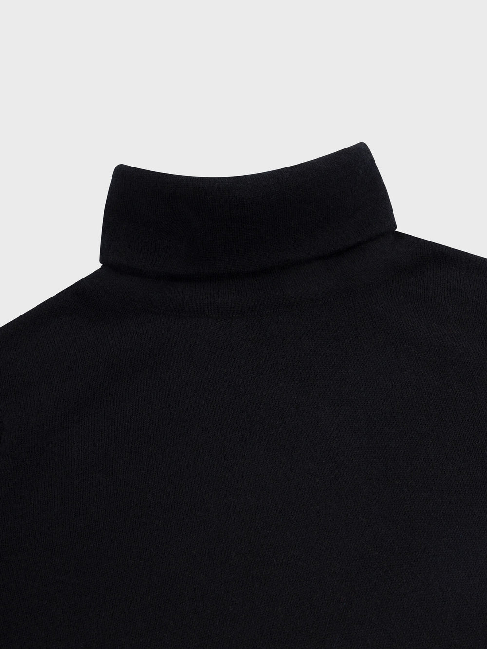 Close-up of a black turtleneck sweater on a light gray background